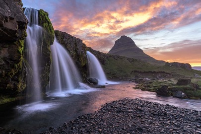 Der Wasserfall Kirkjufellsfoss bildet im Zusammenspiel mit dem Berg Kirkjufell im Hintergrund eines der landschaftlichen Highlights in Island. Die Aufnahme entstand bei Sonnenaufgang im Juni.